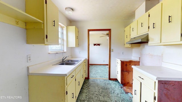 kitchen featuring ceiling fan, sink, and cream cabinets