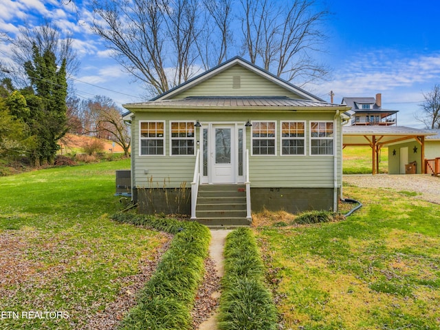 bungalow featuring central AC and a front lawn