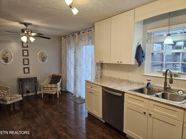 kitchen with sink, hanging light fixtures, stainless steel dishwasher, a textured ceiling, and tasteful backsplash