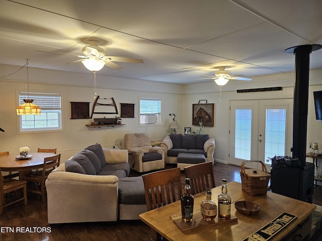 dining area featuring a wood stove, ceiling fan, dark hardwood / wood-style flooring, and french doors