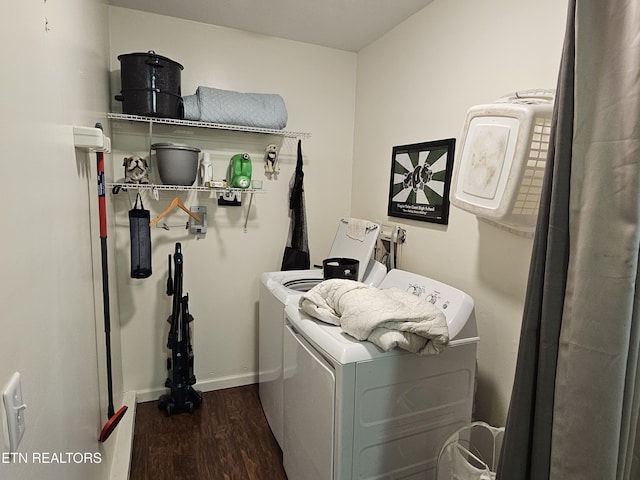 clothes washing area featuring washer and clothes dryer and dark wood-type flooring