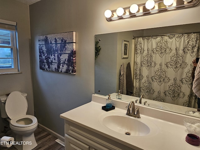 bathroom featuring a shower with shower curtain, vanity, wood-type flooring, and toilet