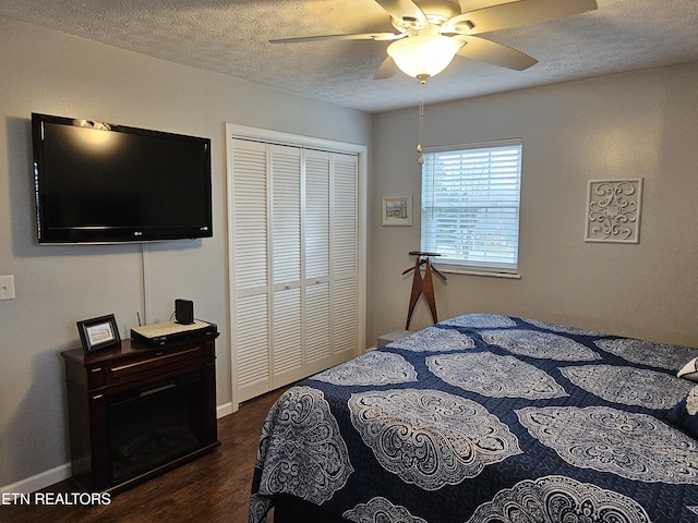 bedroom featuring dark hardwood / wood-style flooring, a textured ceiling, a closet, and ceiling fan