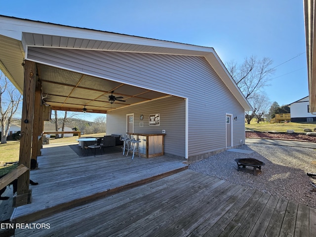 wooden terrace featuring outdoor dining area and a ceiling fan