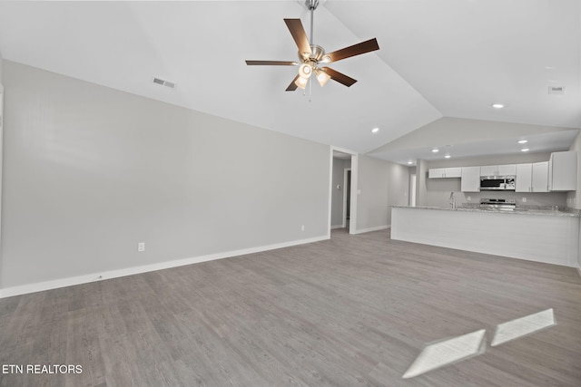 unfurnished living room with ceiling fan, sink, light hardwood / wood-style floors, and lofted ceiling