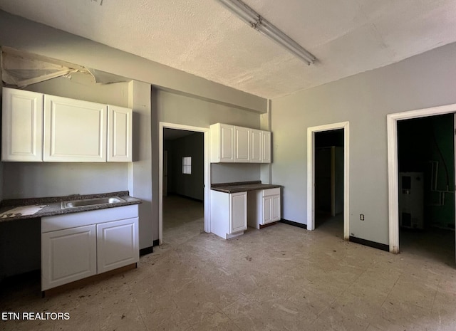 kitchen featuring white cabinetry and sink