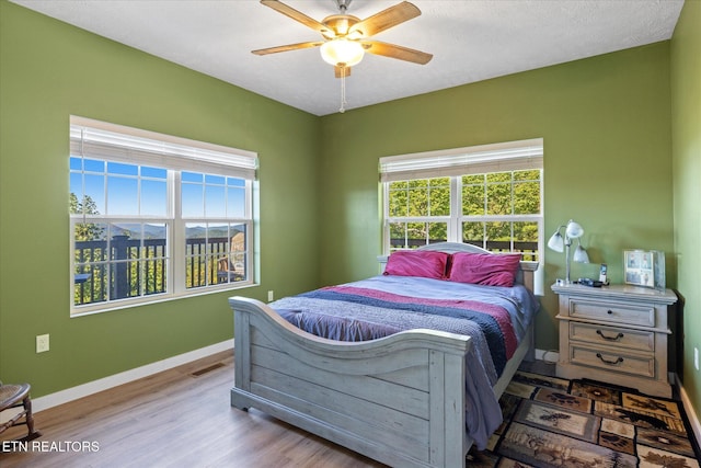 bedroom with ceiling fan and hardwood / wood-style flooring