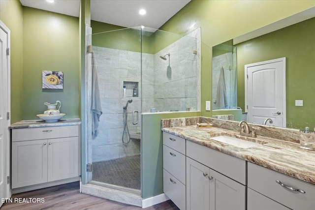 bathroom with vanity, an enclosed shower, and hardwood / wood-style flooring