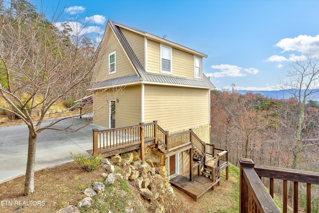 rear view of property featuring a patio area and a deck