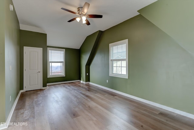 additional living space featuring ceiling fan, light wood-type flooring, and lofted ceiling