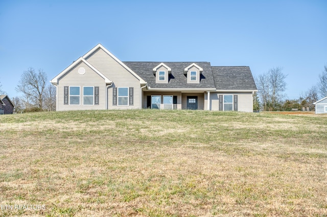 cape cod home featuring a front lawn