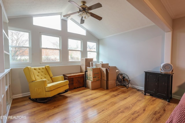 living area featuring ceiling fan, crown molding, light hardwood / wood-style floors, a textured ceiling, and vaulted ceiling