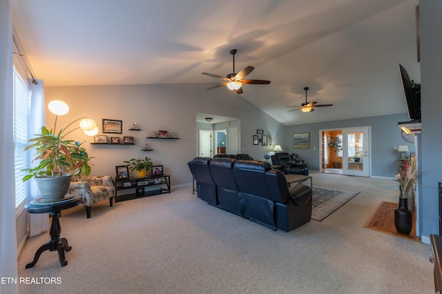 carpeted living room with ceiling fan, plenty of natural light, and vaulted ceiling