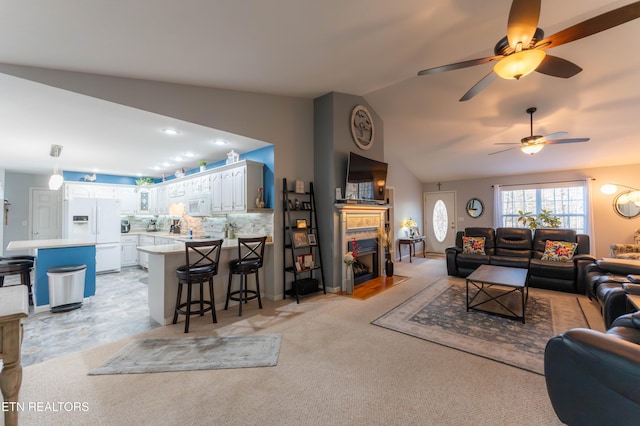 carpeted living room with ceiling fan and lofted ceiling