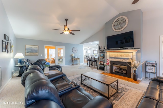 carpeted living room featuring ceiling fan, lofted ceiling, and a premium fireplace