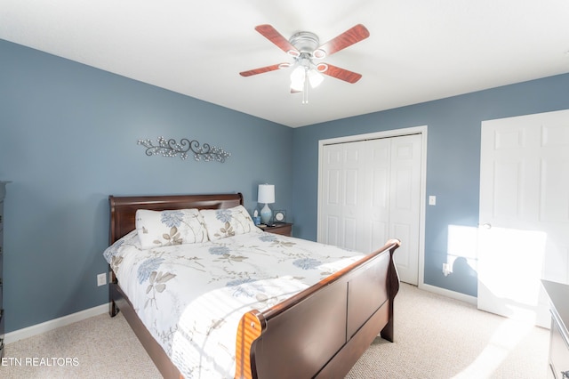 bedroom with ceiling fan, light carpet, and a closet