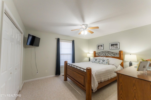 carpeted bedroom featuring ceiling fan and a closet