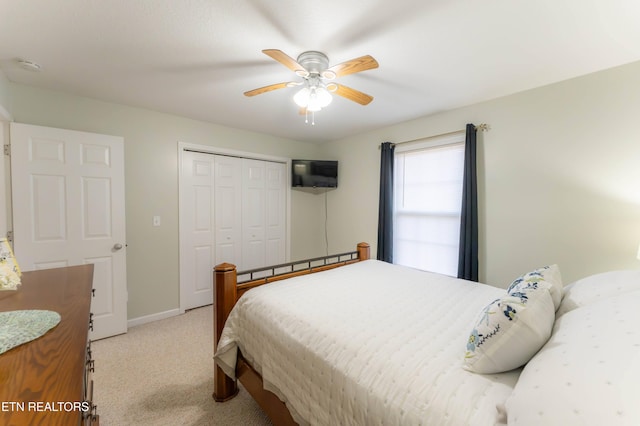 bedroom featuring ceiling fan, light carpet, and a closet