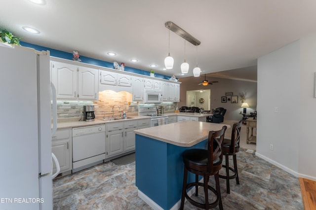 kitchen featuring ceiling fan, a center island, sink, white appliances, and white cabinets