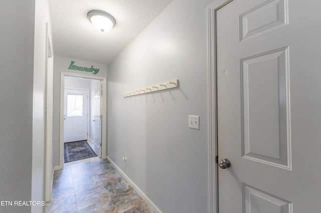 doorway to outside featuring a textured ceiling