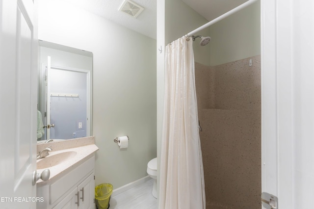 bathroom with toilet, vanity, and a shower with shower curtain