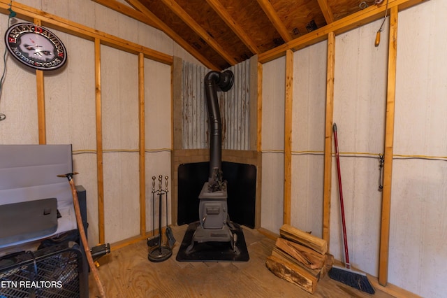 interior space with vaulted ceiling and a wood stove