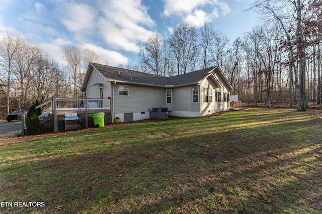 view of side of home featuring a lawn, a deck, and central air condition unit