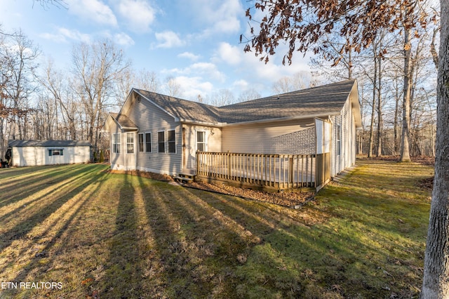 view of property exterior with a yard, a storage shed, and a wooden deck