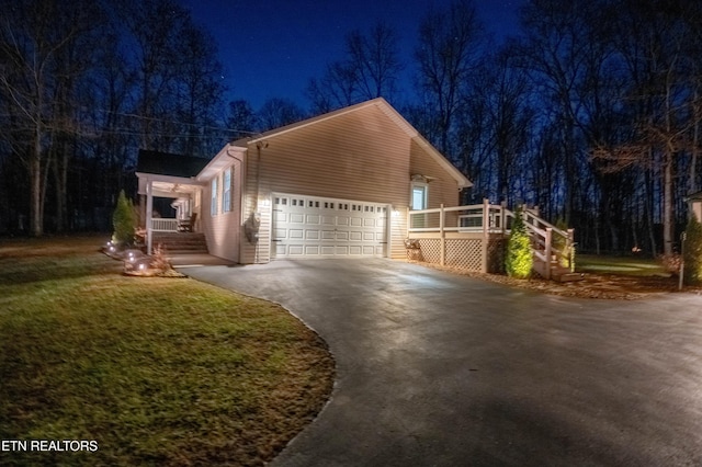 view of front of home featuring a wooden deck, a yard, and a garage