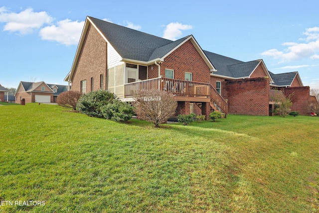 rear view of property featuring a yard and a wooden deck