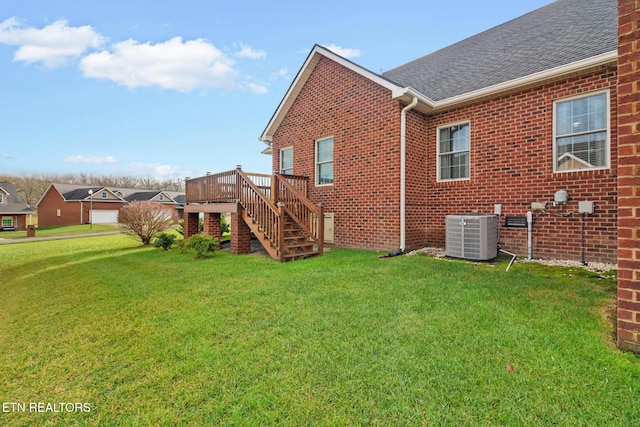 exterior space featuring central air condition unit, a deck, and a lawn