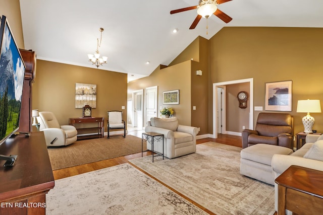 living room with high vaulted ceiling, wood-type flooring, and ceiling fan with notable chandelier