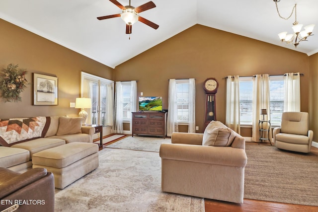 living room featuring ceiling fan with notable chandelier, high vaulted ceiling, light hardwood / wood-style flooring, and plenty of natural light