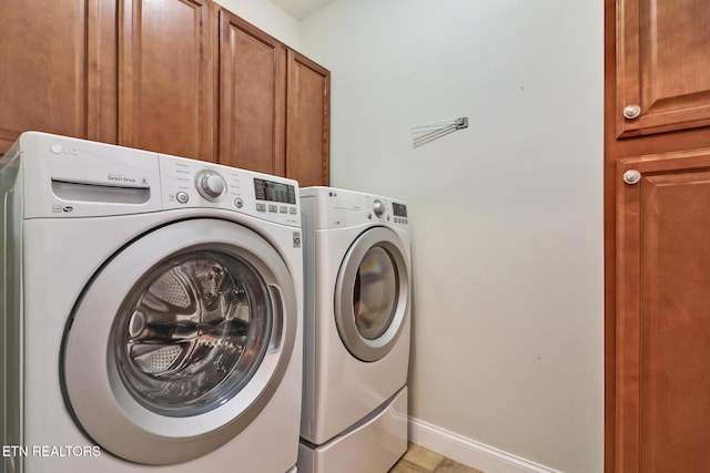 laundry area featuring washer and dryer and cabinets