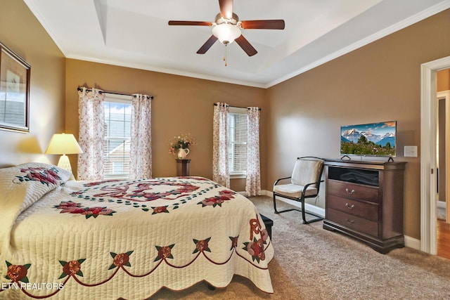 bedroom featuring carpet floors, a tray ceiling, ceiling fan, and ornamental molding