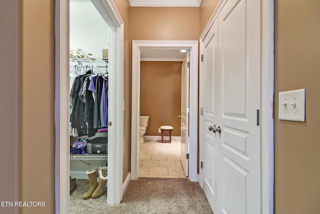 hallway with light colored carpet and crown molding