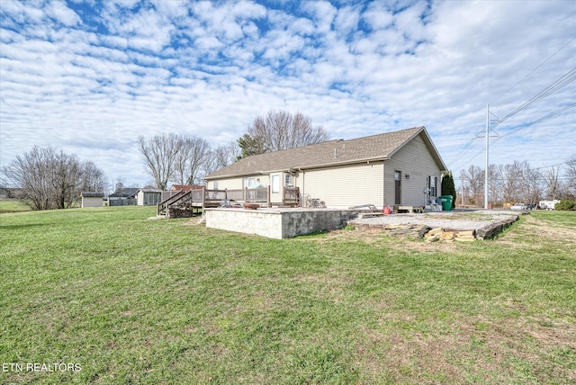 view of side of property with a wooden deck and a lawn