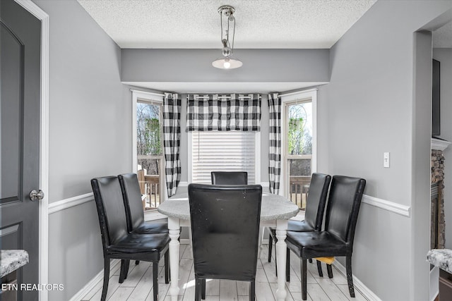 dining space featuring a textured ceiling and light hardwood / wood-style floors