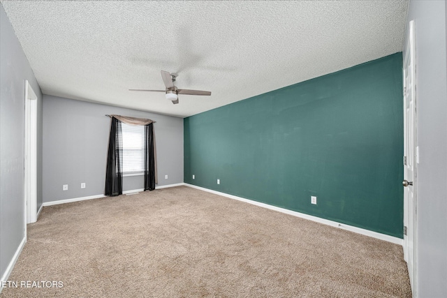 empty room featuring a textured ceiling, ceiling fan, and carpet