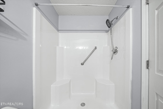 bathroom with walk in shower and a textured ceiling