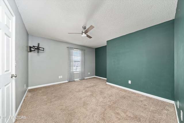 carpeted empty room featuring ceiling fan and a textured ceiling