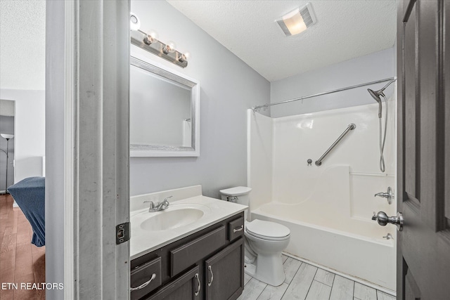 full bathroom with vanity, tub / shower combination, a textured ceiling, and toilet