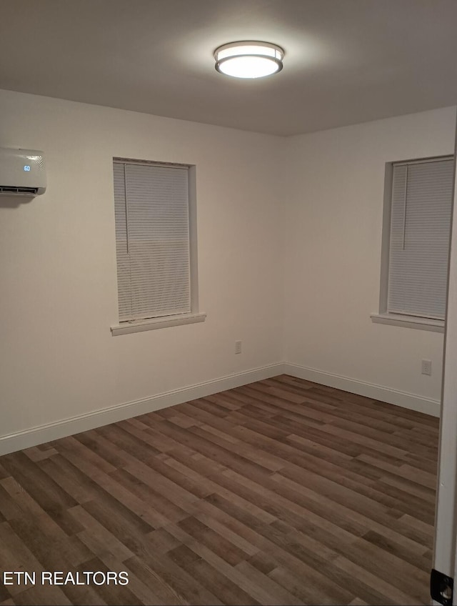 unfurnished room with dark wood-type flooring and a wall mounted air conditioner