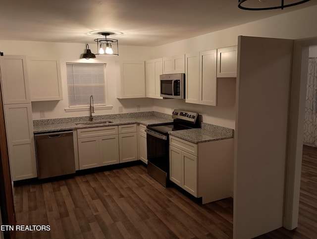 kitchen with white cabinets, stainless steel appliances, light stone counters, and sink