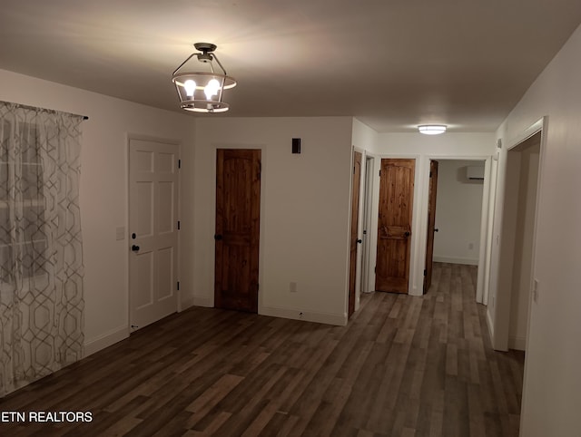 spare room with a chandelier and dark hardwood / wood-style floors