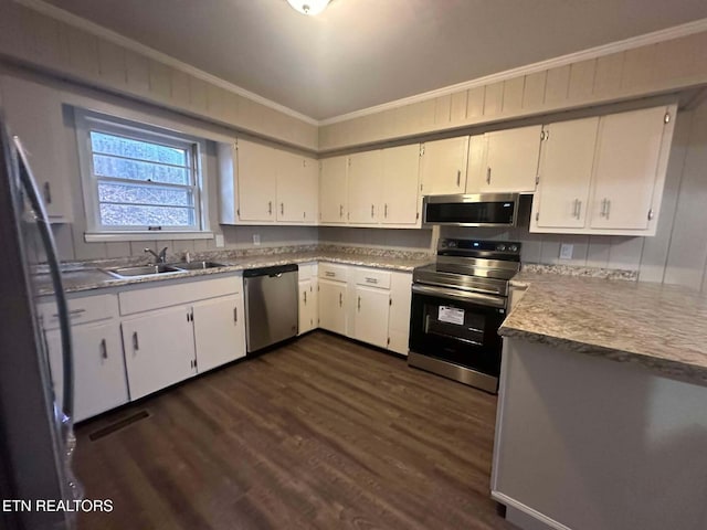 kitchen featuring appliances with stainless steel finishes, dark hardwood / wood-style flooring, crown molding, sink, and white cabinetry