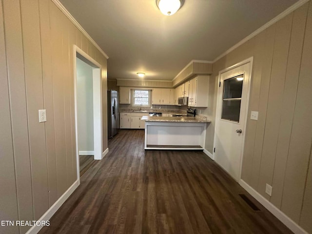 kitchen with white cabinetry, stainless steel appliances, dark wood-type flooring, kitchen peninsula, and crown molding