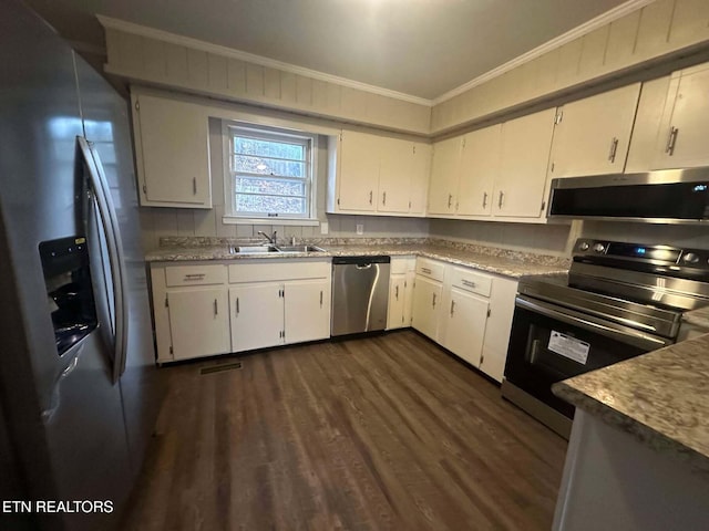 kitchen with appliances with stainless steel finishes, crown molding, sink, dark hardwood / wood-style floors, and white cabinetry