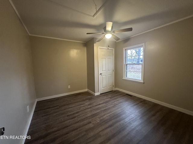 unfurnished bedroom featuring ceiling fan, dark wood-type flooring, and ornamental molding