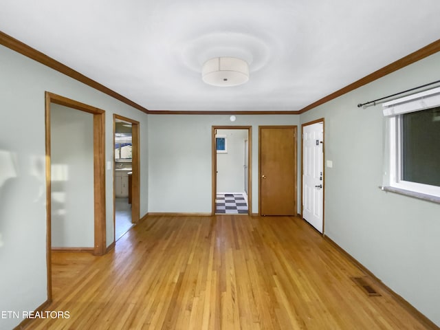 interior space featuring crown molding and light hardwood / wood-style flooring